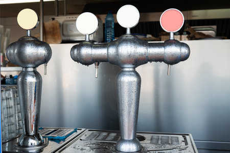 Bar tap dispensers with three different color handles in a refreshment facility.の写真素材