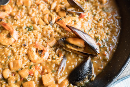 Delicious seafood paella with shrimp and mussels in a pan.の写真素材