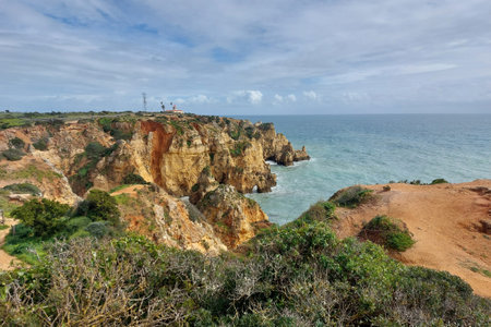 Capture the natural beauty of coastal cliffs and the serene sea under a dramatic cloudy sky in a scenic landscapeの写真素材