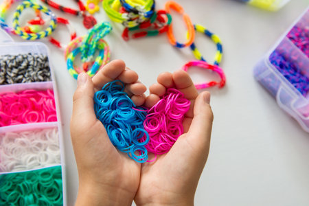 Child's hands holding colorful loom bands for bracelet making.の写真素材