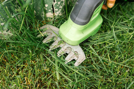 Close-up of electric grass shears cutting lawn for precise garden maintenance.の写真素材