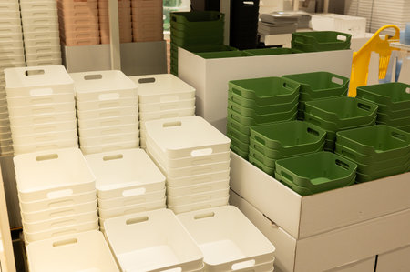 Stacked white and green plastic storage bins in store display.