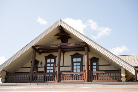Wooden cabin exterior with gabled roof and sky background.