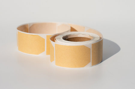 Roll of blank beige adhesive labels on white background.の写真素材