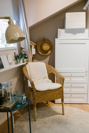 Cozy modern living space with wicker chair and neutral decor.の写真素材