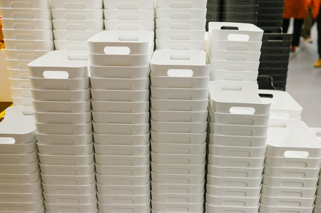 Stacked white plastic storage bins in warehouse setting.の写真素材