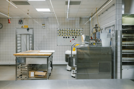 Industrial kitchen with stainless steel equipment and tiled walls.の写真素材