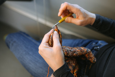 Young caucasian female knitting with crochet hook in hands.の写真素材