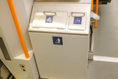 Train waste disposal bin with recycling and trash compartments in public transport.の写真素材
