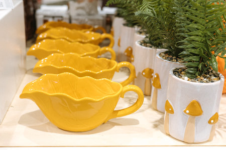 Yellow leaf-shaped dishes and mushroom planters in a decorative display.の写真素材