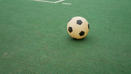 Soccer ball on green field turf with white lines.の写真素材