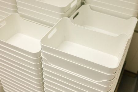 Stacked white plastic storage bins in warehouse setting.の写真素材