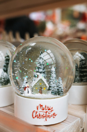 Festive snow globe with Christmas scene of snowman and cabin.の写真素材
