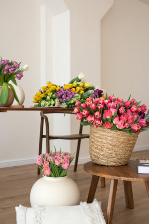 Vibrant display of multicolored tulips in modern interior setting with wooden furniture.の写真素材