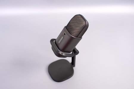 Black metal microphone on stand with minimalist background.の写真素材