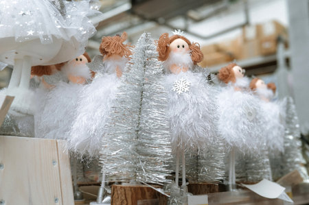 Festive christmas angel dolls with silver trees in winter display.の写真素材