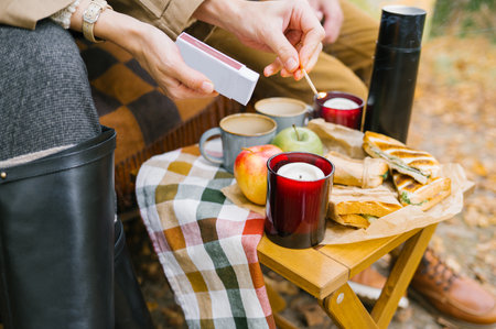 Cozy autumn picnic with candles, apples, and sandwiches.の写真素材