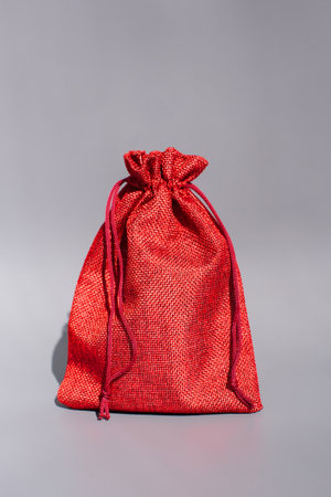 Vibrant red drawstring bag with textured fabric on gray background.の写真素材