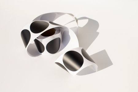 Roll of black circle stickers on white background.の写真素材