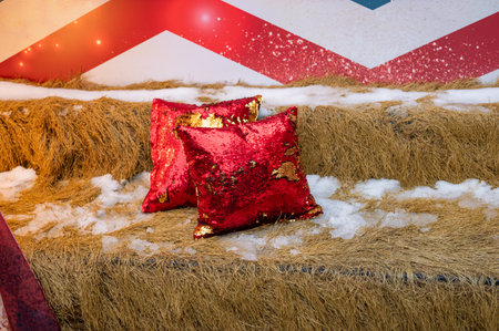 Festive red sequin pillows on straw with snowflakes and holiday decor.の写真素材