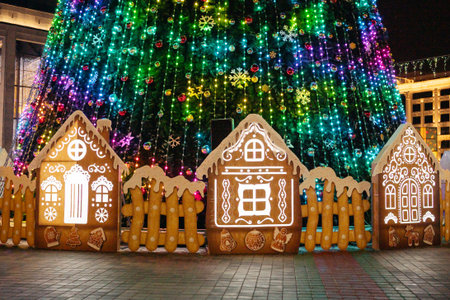 Colorful christmas tree with illuminated gingerbread houses at night.の写真素材