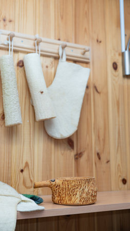 Cozy sauna interior with natural wooden elements and hanging bath accessories.の写真素材