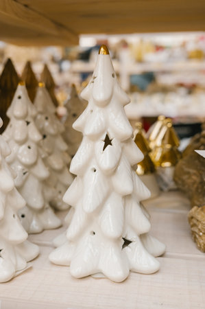 White ceramic christmas trees with star cutouts in festive display.の写真素材