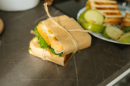 Fresh grilled sandwich with lettuce and green apples on marble countertop.の写真素材