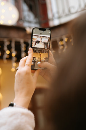 Female capturing outdoor scene with smartphone.の写真素材