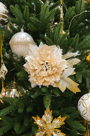 Elegant christmas tree with white and gold decorations and a large flower.の写真素材