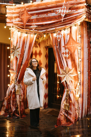 Female adult caucasian enjoying festive outdoor christmas decorations.の写真素材