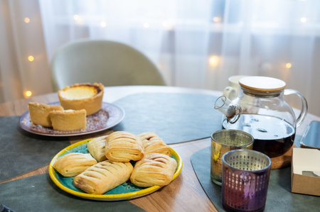 Cozy breakfast setting with fresh pastries and tea on a wooden table.