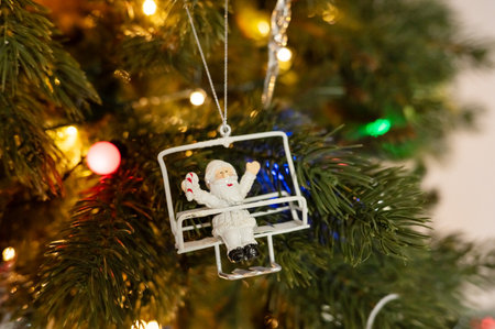 Santa ornament on christmas tree with lights and pine branches.の写真素材