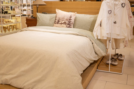 Cozy bedroom display with wooden bed frame and comfy bedding in home store.の写真素材