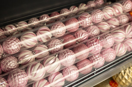 Pink and silver christmas ornaments in plastic packaging on store shelf.の写真素材