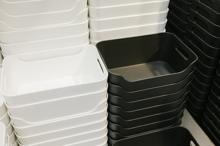 Stacked black and white storage bins in various sizes.