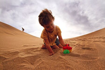Babyboy playing in a desertの写真素材