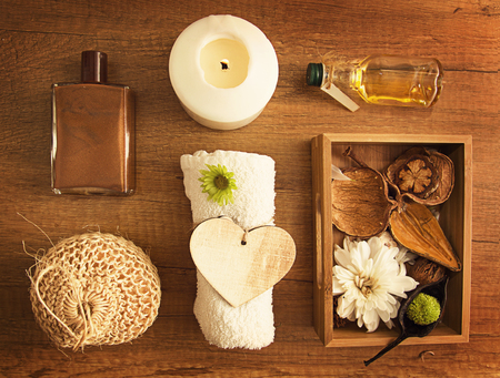 Spa dry flowers decorations on wooden surface with wooden heart and oilの写真素材