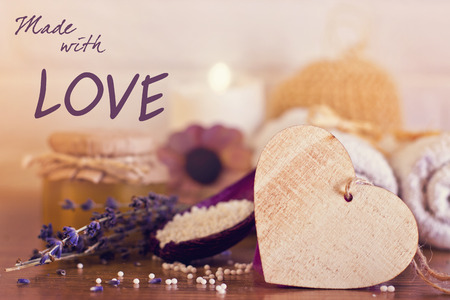 Spa and wellness setting with white towels , sponge, candle, lavender and wooden heart on bricks wall background. Valentine's postcard "made with love". の写真素材