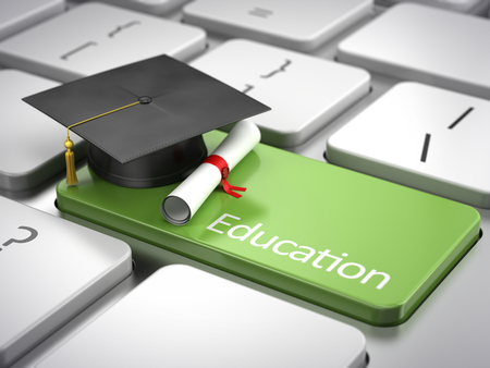 graduation cap and diploma on keyboard - education concept
