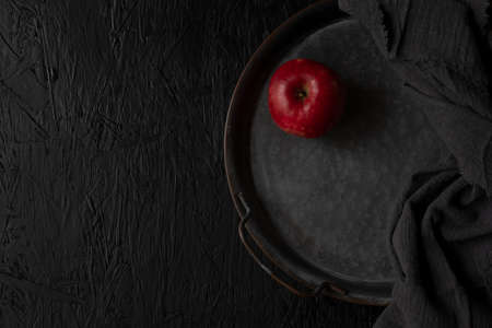 Red apple isolated on black wooden background