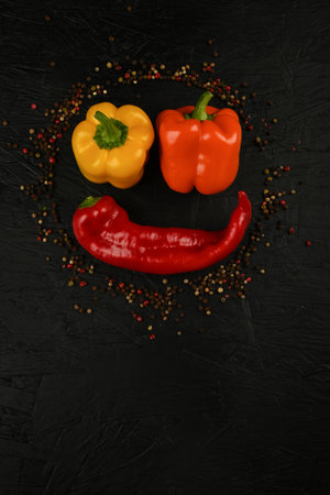 fresh and delicious, yellow, red and orange peppers on black background.の写真素材