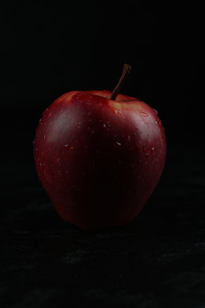 Red apple isolated on black wooden background