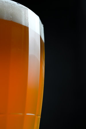 beer in a glass on a black background.