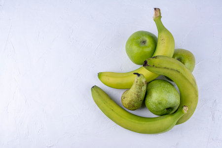 Fresh green apples, pears, bananas on a white wooden background. Concept healthy food photoの写真素材