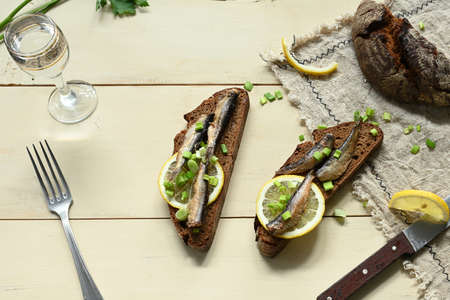 Sandwich with sprats. Sprat in oil. On a wooden background.の写真素材
