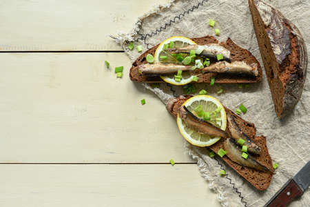 Sandwich with sprats. Sprat in oil. On a wooden background.の写真素材