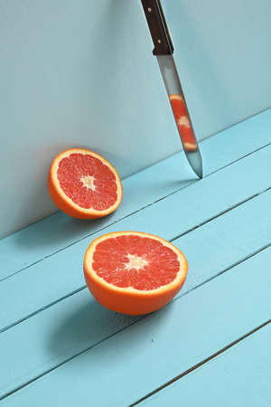 Red grapefruit cut in half on a blue wooden rustic background.の写真素材