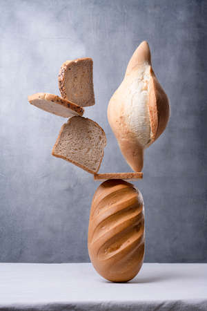 balancing bread on a table on a gray background.の写真素材