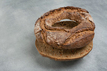 rye bread in the form of a roll lies on a gray table. rustic style.